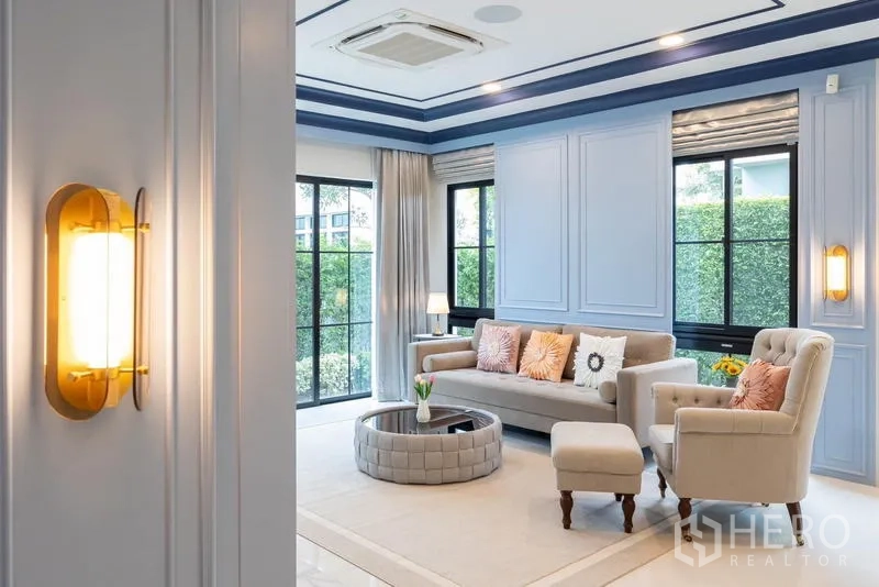 Detached House for sale in Saphan Sung, Bangkok - Living area with accent sconce, large windows and neutral sofa set.