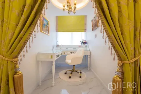 Townhouse for rent in Lat Phrao, Bangkok - Bright study nook with white desk and chair framed by green tassel curtains.