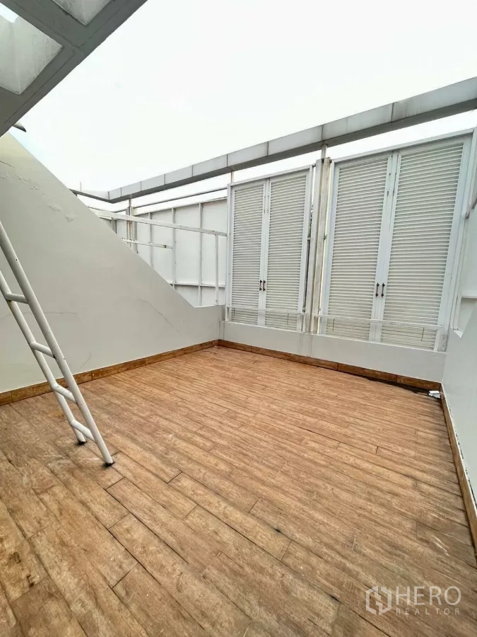 Home Office for rent in Khlong Toei, Bangkok - Open terrace with wood-look tiles and ladder to rooftop access.