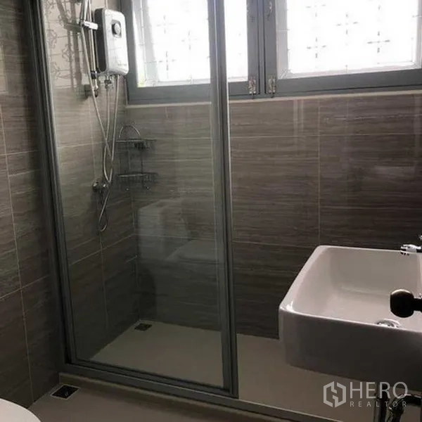 Detached House for rent in Phra Khanong, Bangkok - Second bathroom with glass shower enclosure beneath frosted windows.