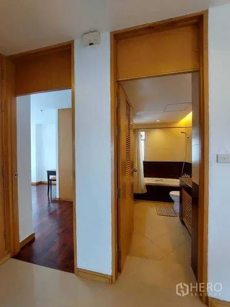 Apartment for rent - Hallway leading to a bathroom and a bright room with wooden flooring.