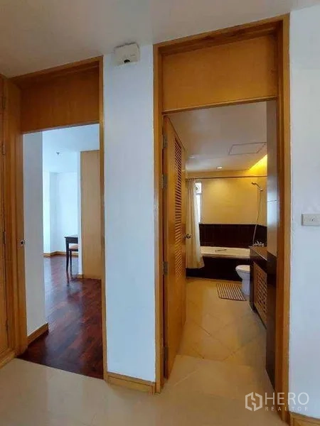Apartment for rent - Hallway leading to a bathroom and a bright room with wooden flooring.