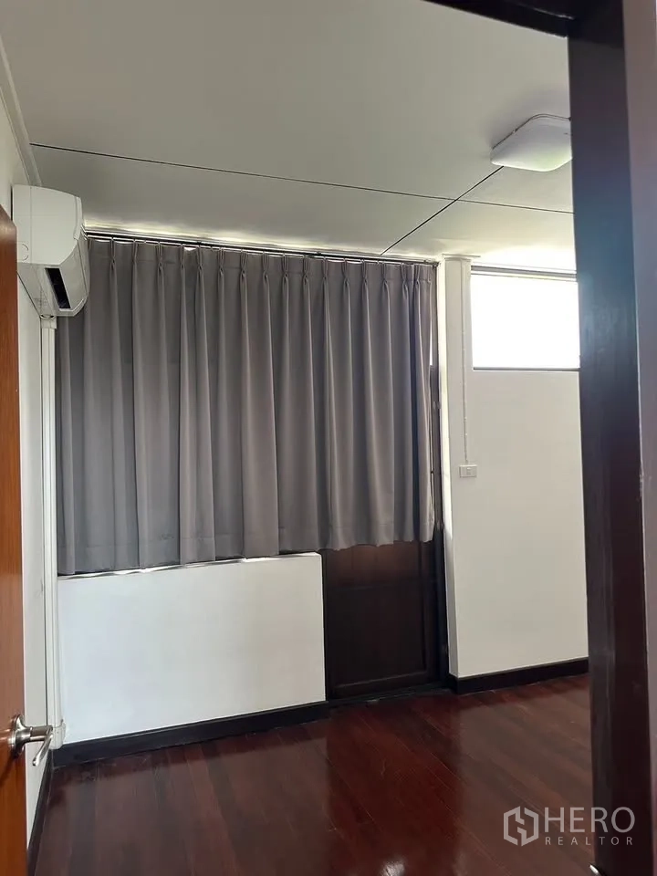 Detached House for rent in Phra Khanong, Bangkok - Small bedroom with air conditioner, curtains and wooden floor.