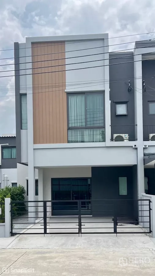 Townhouse for rent in Bang Phli, Samut Prakan - Modern two-story townhouse exterior with gated carport and large windows.
