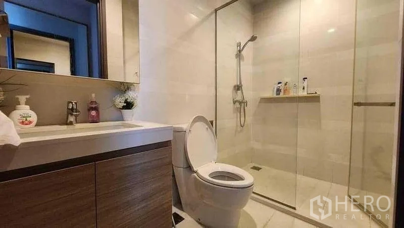 Condominium for rent in Khlong Toei, Bangkok - Guest bathroom with vanity, toilet and large glass shower.