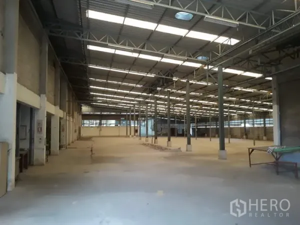 Factory for rent in Thanyaburi, Pathum Thani - Open-plan factory area with multiple steel columns and skylight panels for natural light.