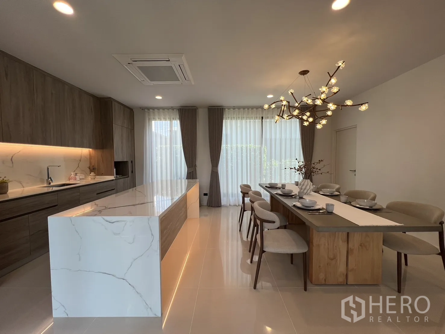 独立式住宅 出租或出售在Bang Kapi, Bangkok - 大理石瀑布台面岛台，内置橱柜与柔和灯光。