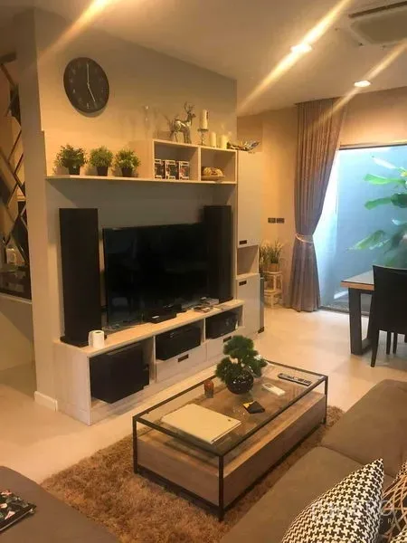 Detached House for rent or sale in Bang Kapi, Bangkok - Cozy living room with TV wall unit, sofa and a glass coffee table.