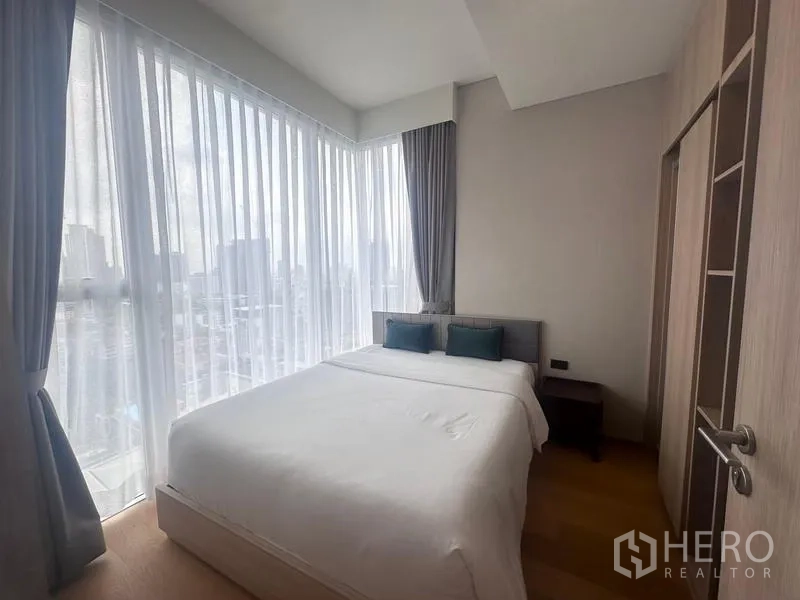 Condominium for rent - Corner bedroom with king bed, sheer curtains and panoramic city views.
