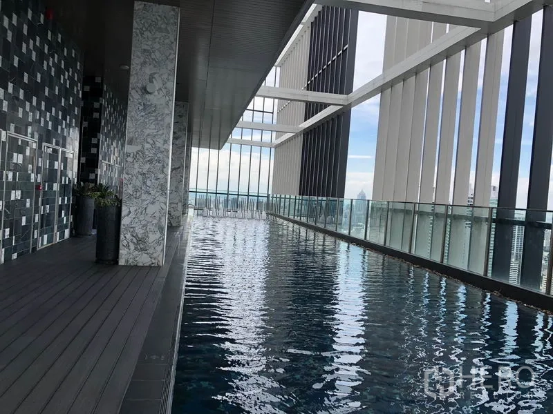 Condominium for rent in Khlong Toei, Bangkok - Rooftop infinity pool with glass railing and panoramic Bangkok skyline views.