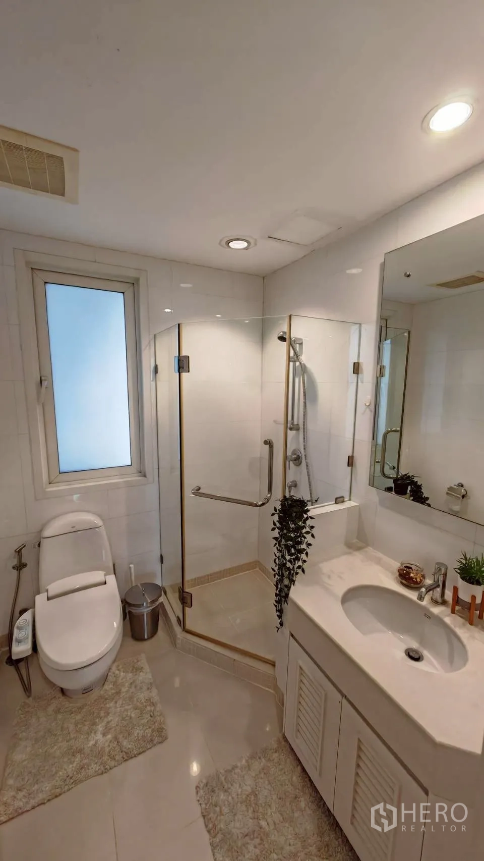 公寓 for rent in Khlong Toei, Bangkok - 明亮浴室配玻璃淋浴间、洗手台与窗户。