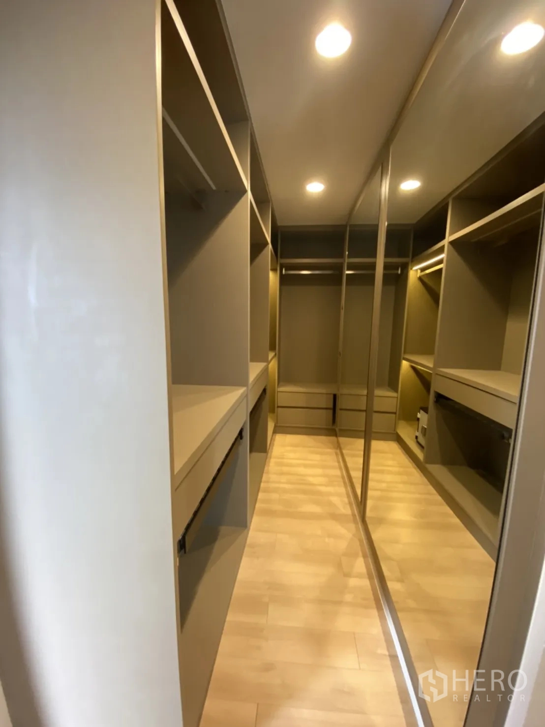 Condominium for rent in Bang Rak, Bangkok - Spacious walk-in closet with built-in shelves and mirrored doors.