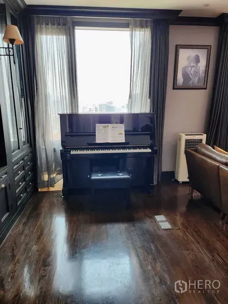 Condominium for sale in Khlong Toei, Bangkok - Upright piano by sheer-curtained window on glossy hardwood floors.