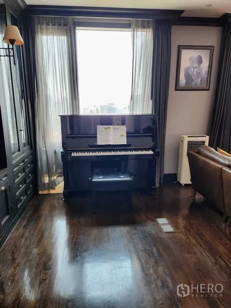 Condominium for sale in Khlong Toei, Bangkok - Upright piano by sheer-curtained window on glossy hardwood floors.