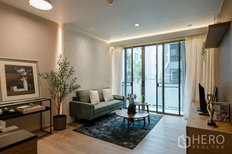 Condominium for sale - Open-plan living area with sofa, coffee table and balcony access.