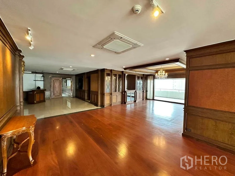 Condominium for rent in Bangkok - Expansive living and dining area with hardwood floors, wood paneling and balcony access.