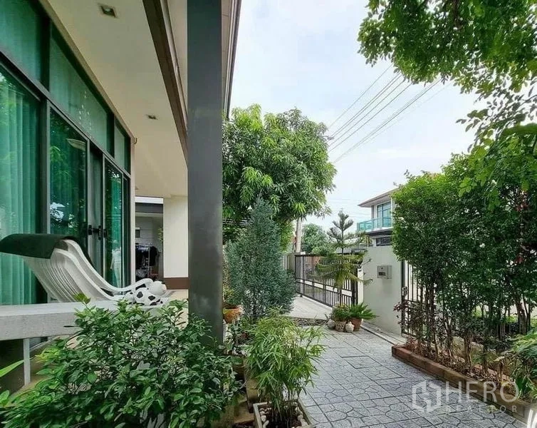 Detached House for sale in Prawet, Bangkok - Shaded walkway along landscaped garden leading to the front gate.