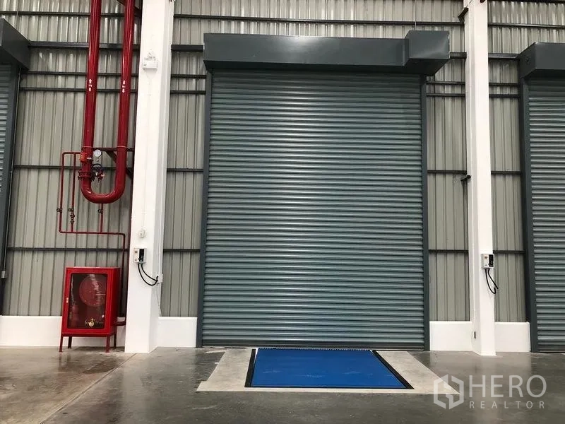 Factory for rent in Wang Noi, Phra Nakhon Si Ayutthaya - Close-up loading bay with dock leveler, roller shutter, and fire safety system.