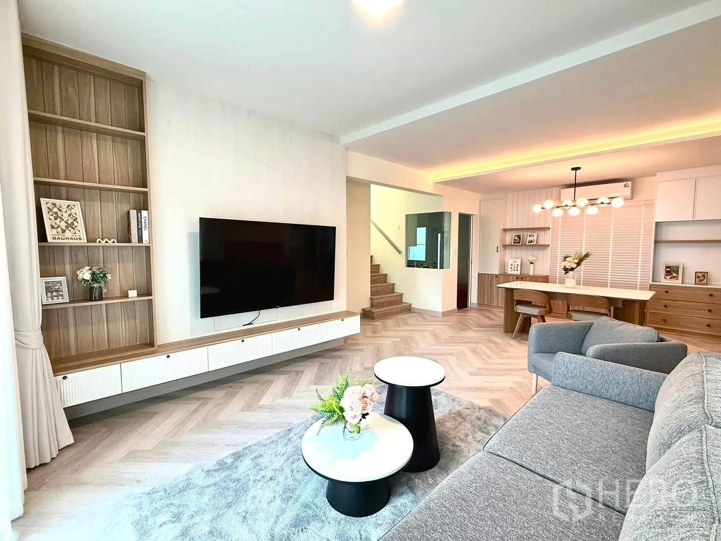 独栋房屋 for rent in Bang Phli, Samut Prakan - 开放式客厅，灰色沙发、电视墙、搁架与楼梯。