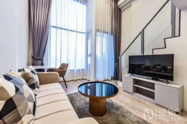 คอนโด ให้เช่าในHuai Khwang, Bangkok - พื้นที่นั่งเล่นหน้าโทรทัศน์ ใต้ผ้าม่านสูงและบันไดสมัยใหม่