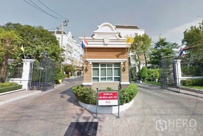 联排别墅 出租在Prawet, Bangkok - 设有门禁与岗亭的社区入口，周围绿化良好。