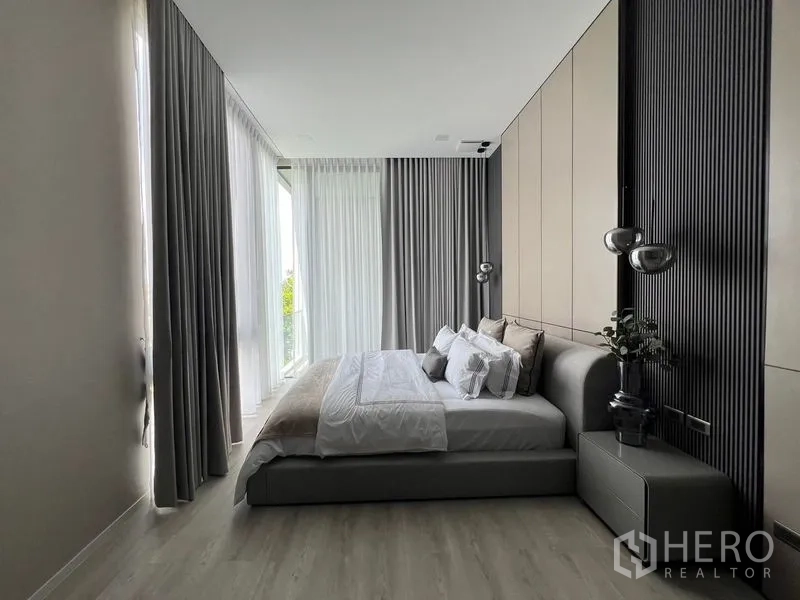 Detached House for rent in Saphan Sung, Bangkok - Bedroom with full-height curtains, modern pendant lighting and soft tones.