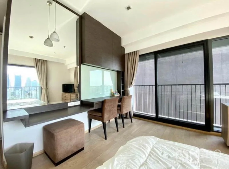 Condominium for rent in Khlong Toei, Bangkok - Bedroom with large sliding glass doors, double work desk and mirror, and balcony railings.