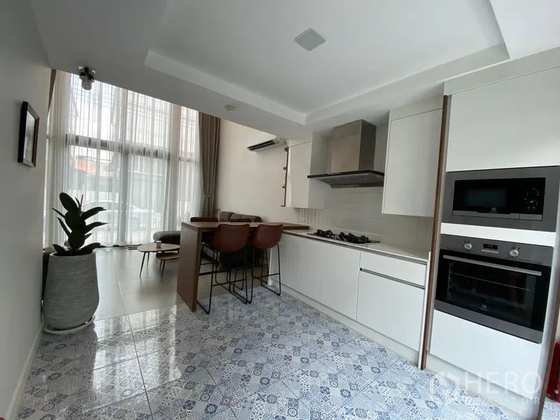 Townhouse for rent in Suan Luang, Bangkok - Bright kitchen featuring patterned tile floor, built-in ovens and floor-to-ceiling windows.