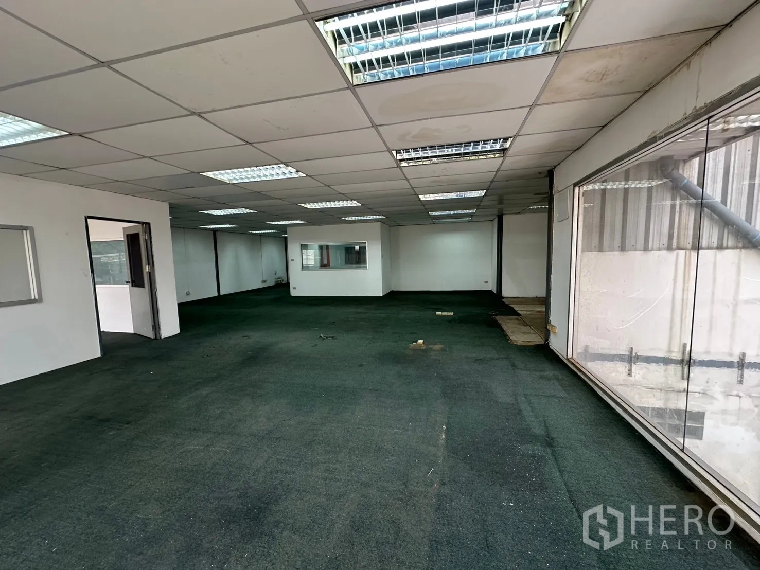 Warehouse for rent in Suan Luang, Bangkok - Wide view of a carpeted office floor with glass walls and natural light.