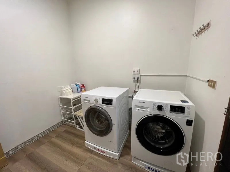 Townhouse for rent or sale in Suan Luang, Bangkok - Laundry room with Bosch and Samsung front-loading washing machines.