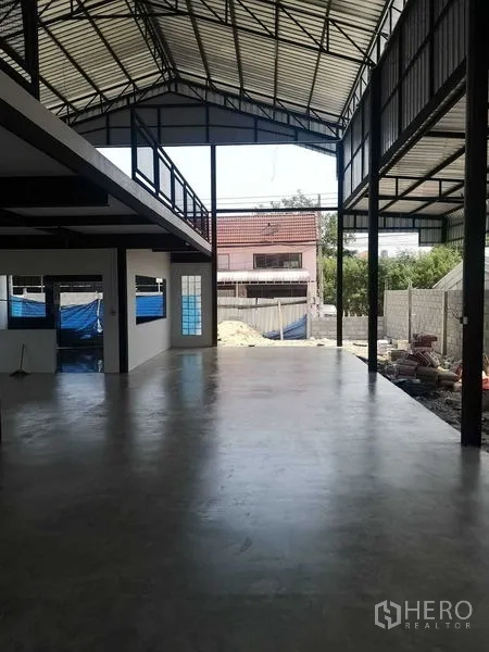 Factory for rent or sale in Mueang Samut Prakan, Samut Prakan - Airy factory interior with high steel roof, polished concrete floor and mezzanine walkway opening to the yard.