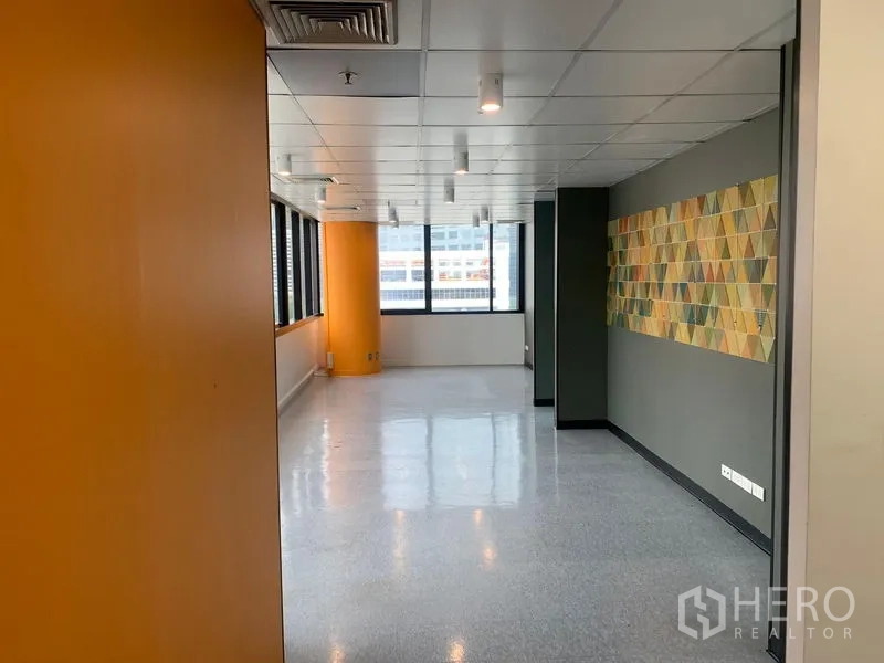 Office Space for rent in Bang Rak, Bangkok - Bright workspace with orange column, spot lighting, and geometric wall art.