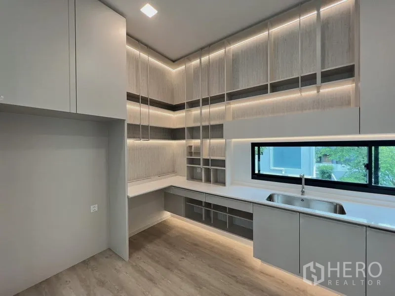 Detached House for rent or sale in Saphan Sung, Bangkok - Modern pantry with L-shaped counter, sink, and abundant cabinetry.