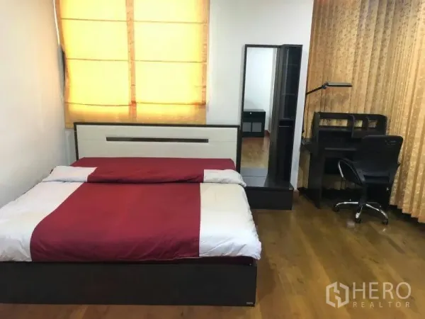 公寓 出租在Watthana, Bangkok - 舒适卧室，双人床、书桌椅、穿衣镜与落地窗帘。