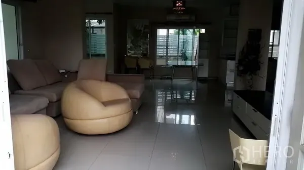Detached House for rent in Lat Krabang, Bangkok - Open-plan living room with beige sofas, glossy tile flooring, and large windows in a Lat Krabang house.