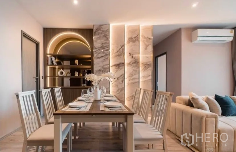 Condominium for rent in Watthana, Bangkok - Spacious dining zone with arched backlit shelving and six chairs.