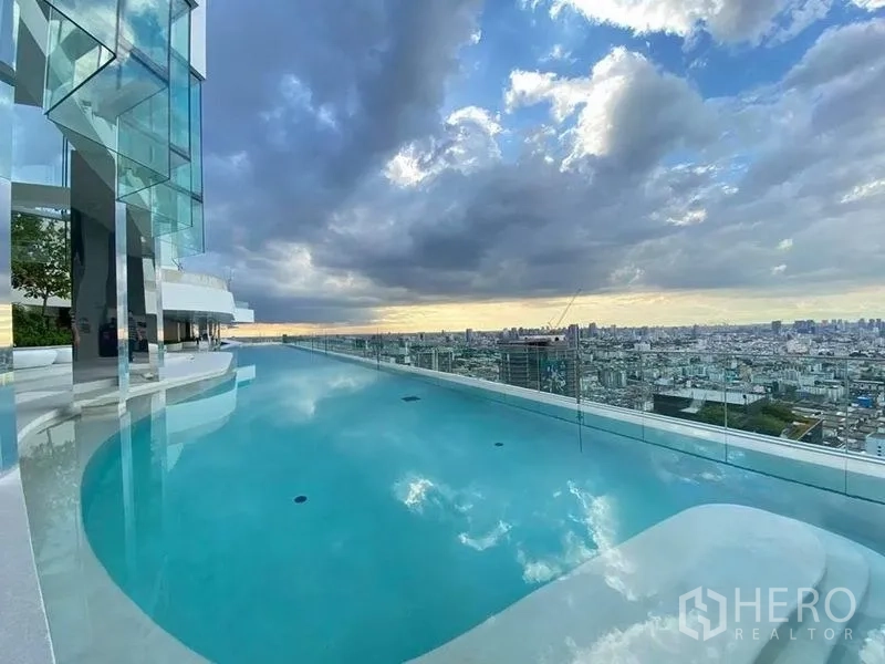 公寓 出售在Ratchathewi, Bangkok - 屋顶无边泳池，玻璃护栏俯瞰曼谷日落景致。