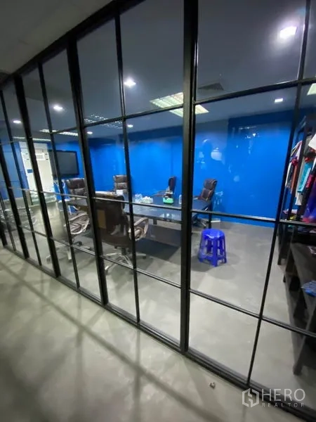 办公空间 出租在Khlong Toei, Bangkok - 玻璃墙会议室，蓝色特色墙，会议桌与行政椅。