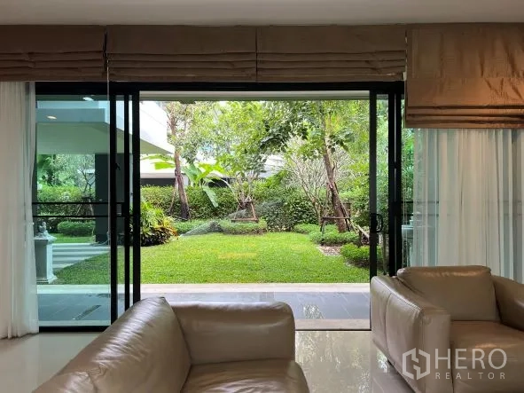 Detached House for rent or sale in Bang Kapi, Bangkok - Garden view from the living room through wide sliding glass doors to a private landscaped yard.