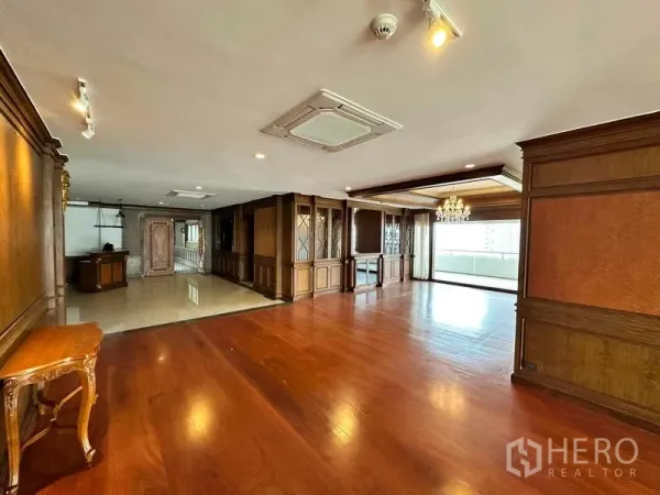 Condominium for rent in Bangkok - Grand open-plan room with classic wood cabinetry and city-facing balcony.