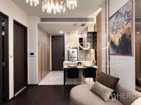 公寓 出租在Watthana, Bangkok - 开放式厨房与餐吧，亮面橱柜和设计感吊灯，曼谷Watthana公寓内景。