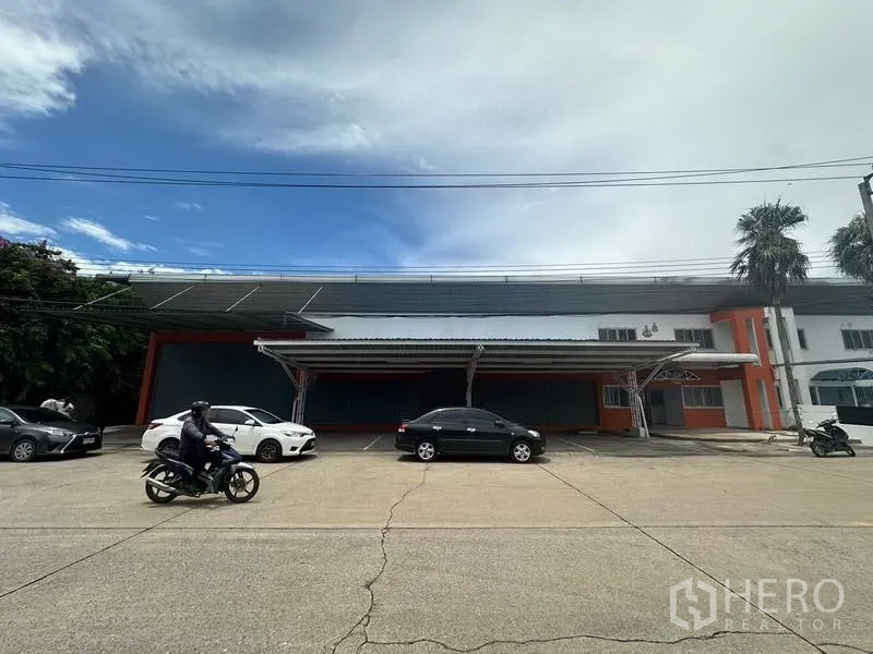 Factory for rent in Nonthaburi - Front elevation of the factory showing covered loading bays and ample on-site parking.