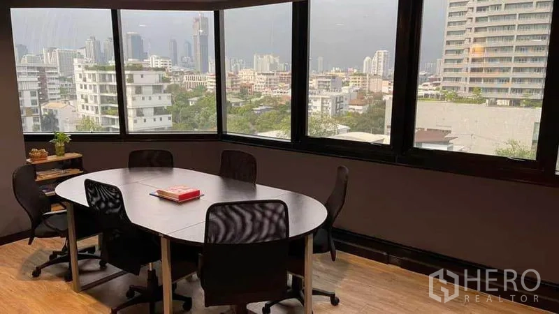 Office Space for rent in Khlong Toei, Bangkok - Small meeting room with an oval table and panoramic city skyline through corner windows.