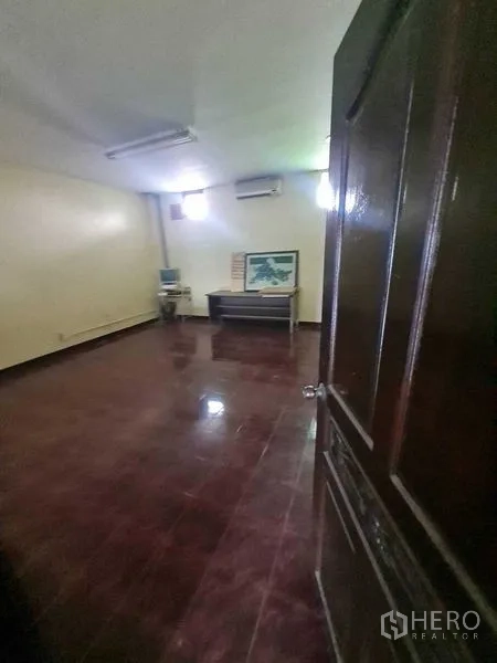 Warehouse for rent in Bang Yai, Nonthaburi - Private office with maroon tiles, desk and wall-mounted air conditioner.