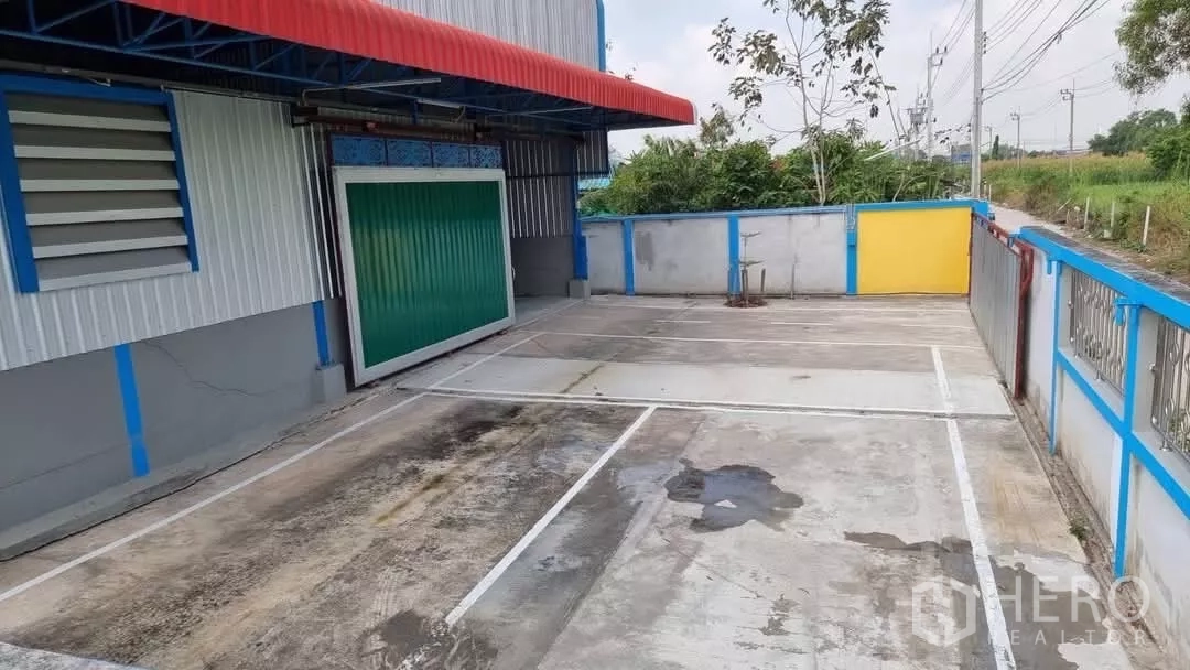 คลังสินค้า ให้เช่าในMin Buri, Bangkok - ลานคอนกรีตส่วนตัว มีช่องจอดรถตีเส้น ประตูโหลดสินค้าแบบม้วนสีเขียว และกันสาด