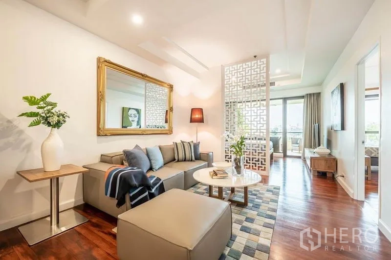 公寓 出租或出售在Khlong San, Bangkok - 舒适客厅，转角沙发、脚凳、大镜子与花格屏风靠近阳台