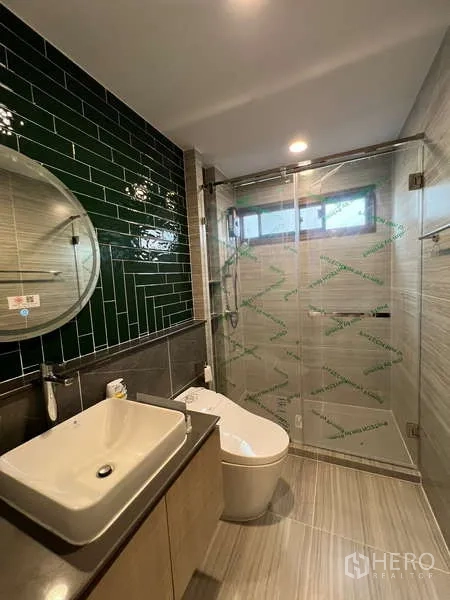 Detached House for rent in Bang Kapi, Bangkok - Bathroom with round mirror, vessel sink and green subway tile feature wall.