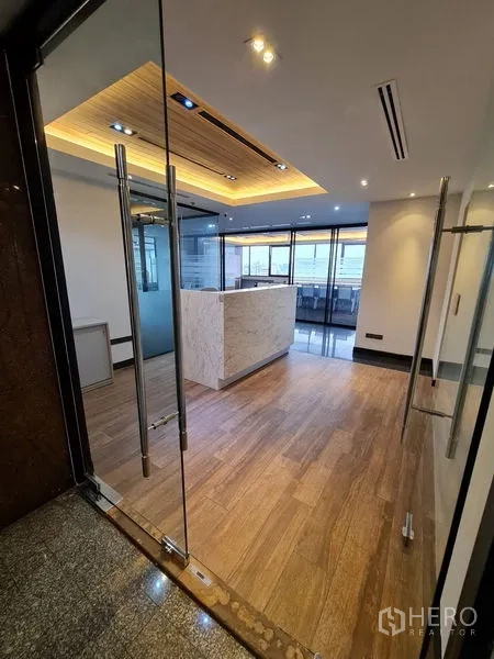 Office Space for rent in Bang Rak, Bangkok - Entrance with glass double doors opening to a warmly lit reception area.