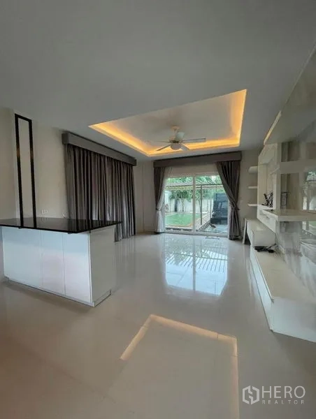 บ้าน ขายในBang Phli, Samut Prakan - พื้นที่นั่งเล่นเปิดออกสู่สวนด้วยประตูกระจกบานเลื่อน ฝ้าเพดานหลุม และชุดทีวีบิวท์อิน