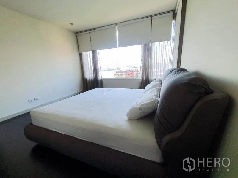 公寓 出租在Khlong San, Bangkok - 主卧侧面视角，宽幅窗户与城市河景。